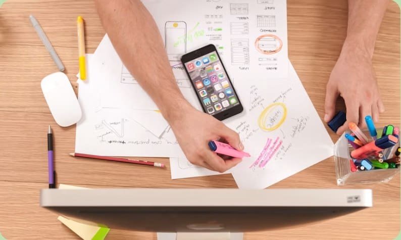 A marketing team annotating campaign plans at a desk